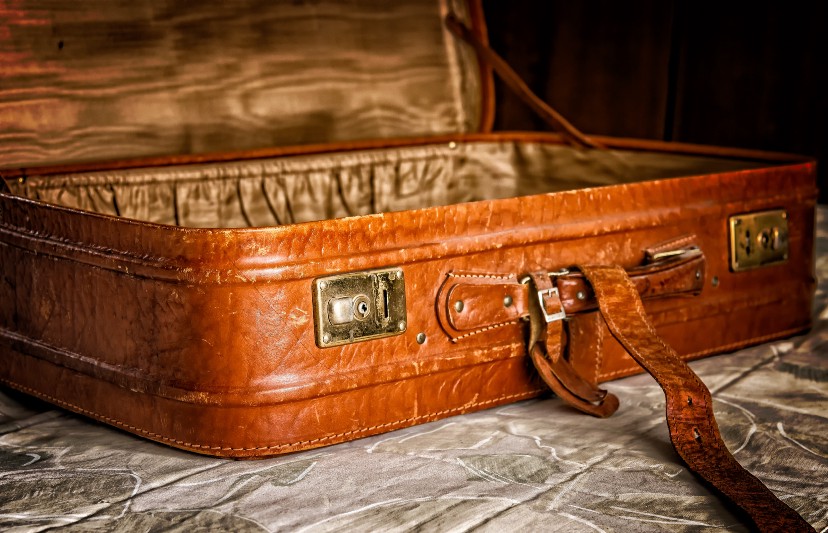 An empty leather suitcase ready for vacation packing. Vaia Magazine 
