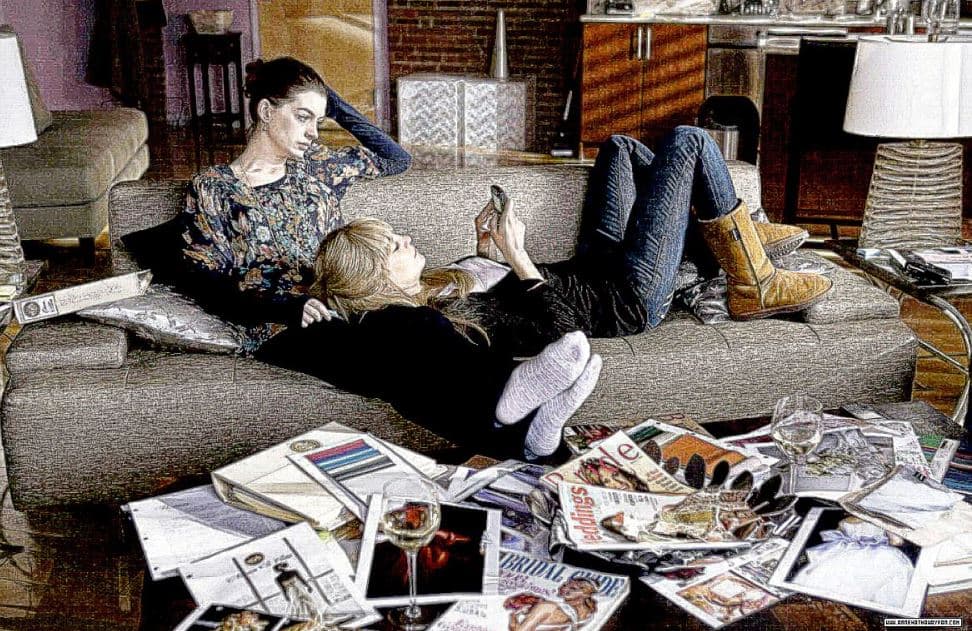 Two female housemates sitting on a couch in a living room, surrounded by magazines and either staring off into the distance or checking their phone. Vaia Magazine